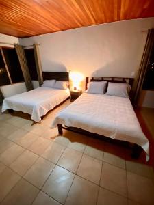a bedroom with two beds and a lamp in it at daBene Francavilla B&B in Alajuela