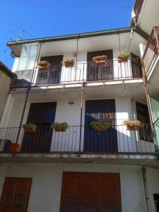 a white building with balconies and potted plants on it at Appartamento Primo Sole in Primaluna