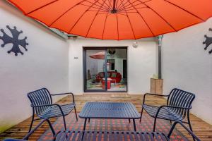 eine Terrasse mit 2 Stühlen und einem Tisch mit einem Sonnenschirm in der Unterkunft Espaces 55, Maison de ville au centre de Lavaur in Lavaur