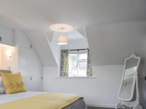 a white room with a bed and a window at Three Batch Cottages in Chaddesley Corbett