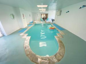a large swimming pool in a large room with a pool at Holemoor Cottage in Bridgerule