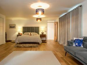 a bedroom with a bed and a couch at Strathspey Lodge in Duthil