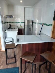 una cocina con barra y dos taburetes. en Cabañas Ases Loft Valdivia SIN ESTACIONAMIENTO, en Valdivia