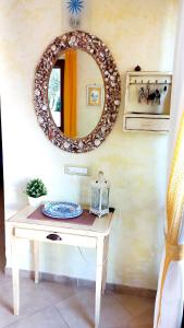um espelho numa parede com uma mesa com um prato em Villa Marea em Torre Santa Sabina