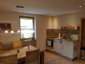 a kitchen with a table and a dining room at Ferienwohnung NatureOne in Kaltennordheim