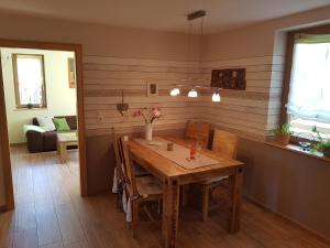 a dining room with a wooden table and chairs at Ferienwohnung NatureOne in Kaltennordheim
