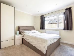 a bedroom with a bed and a large window at Church View in Probus