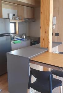 cocina con nevera y mesa con silla en Vivero 5 UF 12 en San Martín de los Andes