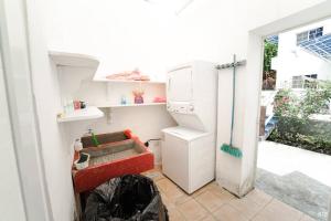 a small kitchen with a refrigerator and a stove at Casa con PISCINA PRIVADA a 4 min del IRTRA REU in Ajaxá