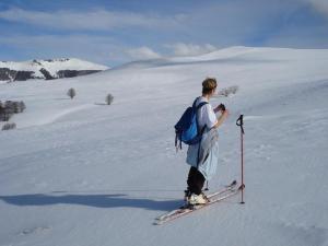 a man is standing on skis in the snow at Auberge Hôtel de Tournemire - Cantal in Tournemire