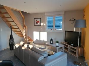 a living room with a couch and a flat screen tv at Les Catèdjes in Fraize