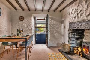 a dining room with a table and a fireplace at Finest Retreats - Harp House in Dolwyddelan