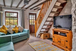a living room with a couch and a flat screen tv at Finest Retreats - Harp House in Dolwyddelan
