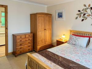 a bedroom with a bed and a wooden dresser at Swallows Rest in Doublebois