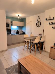 una cucina e una sala da pranzo con tavolo e sedie di Le colibri a Dinard