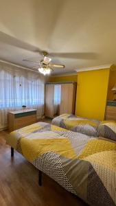 a bedroom with two beds and a ceiling fan at Palaz 6 - 2 bedroom flat in Edmonton