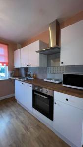 a kitchen with white cabinets and a black oven at Palaz 6 - 2 bedroom flat in Edmonton
