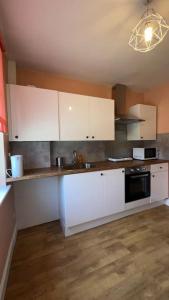 a kitchen with white cabinets and a black appliance at Palaz 6 - 2 bedroom flat in Edmonton