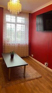 a living room with a table and a red wall at Palaz 6 - 2 bedroom flat in Edmonton