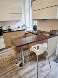 cocina con mesa de madera y sillas blancas en Elizabeth Apartment in the heart of Budapest, en Budapest