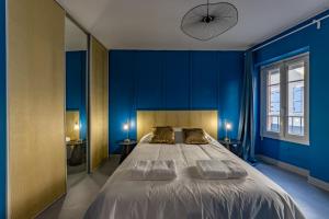 1 dormitorio azul con 1 cama grande y 2 almohadas en Solstice T2 Hypercentre SmartTV Wifi, en Pamiers
