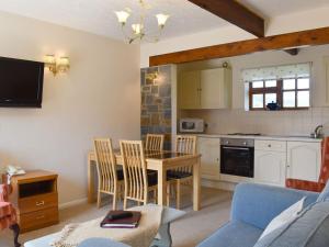 a kitchen and dining room with a table and chairs at The Hay Barn in Sidbury