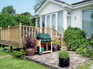 a backyard patio with a grill on a deck at Moonrakers in Ruan Lanihorne