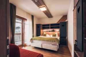 a bedroom with a large bed in a room at Hotel Samerhof - Badestrand inklusive in Tröpolach