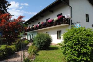 a white building with flowers on a balcony at Gasthof Waldwirt in Sankt Kanzian