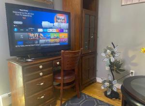 En tv och/eller ett underhållningssystem på Double-Mirrored Glass Room in Queens