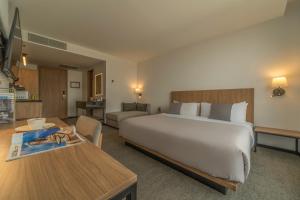 a hotel room with a large bed and a table at Stadía Suites Querétaro Centro Histórico in Querétaro