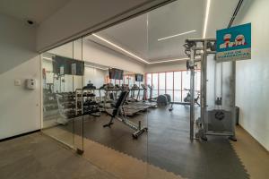 een fitnessruimte met loopbanden en machines in een gebouw bij Stadía Suites Querétaro Centro Histórico in Querétaro