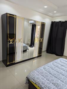 Grand Mbao في Mbaw: غرفة نوم بسرير ومرآة كبيرة