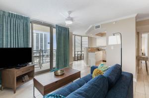 默特尔比奇New to rentals and newly re-decorated - 605 Brighton Kingston Plantation condo的客厅里有一张蓝色沙发和一台电视