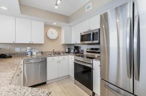 默特尔比奇New to rentals and newly re-decorated - 605 Brighton Kingston Plantation condo的配有白色橱柜和不锈钢冰箱的厨房