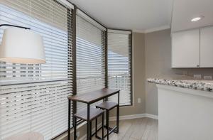 默特尔比奇New to rentals and newly re-decorated - 605 Brighton Kingston Plantation condo的厨房配有桌子和窗前的2把凳子