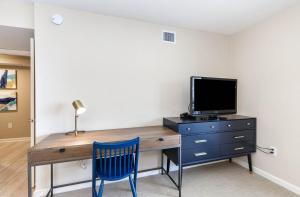 默特尔比奇New to rentals and newly re-decorated - 605 Brighton Kingston Plantation condo的客房设有一张桌子、一台电视和一张蓝色椅子