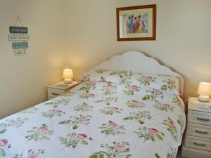 ビードネルにあるDunstanburgh Viewのベッドルーム1室(花柄のベッドカバー付)
