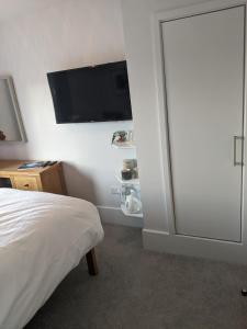 a bedroom with a bed and a flat screen tv at Former Romsey Brewery House in Romsey