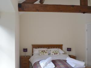 a bedroom with a bed with white sheets and pillows at Betley Court Farm 2 in Betley