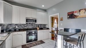 a kitchen with white cabinets and a black counter top at The Jepson Estate on Forsyth Park! in Savannah