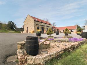 a brick building with flowers in front of a street at The Calf House in Boosbeck