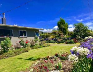 a house with a garden with flowers in the yard at Central Garden Guest House in Motueka