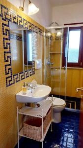 uma casa de banho com um lavatório, um WC e um chuveiro em Villa Marea em Torre Santa Sabina
