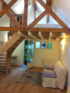 una sala de estar con techo abovedado con vigas de madera. en Maisonnette Rambouillet, en Rambouillet