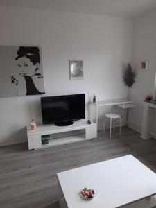 een witte woonkamer met een flatscreen-tv bij Happy Living in Mülheim an der Ruhr