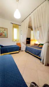 um quarto com 2 camas e um tapete azul em Villa Marea em Torre Santa Sabina