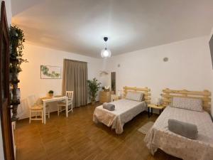 a bedroom with two beds and a table and chairs at B&B and Apartments El Charco Azul in El Risco +44 photos
