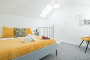 a bedroom with a bed with yellow sheets and a chair at Cosy Two bed Apartment for family and contractors Milton Keynes by O&J Real Estate in Milton Keynes