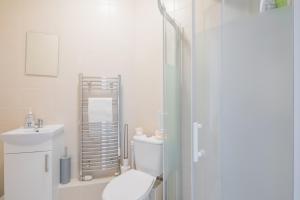 a white bathroom with a toilet and a sink at Cosy Two bed Apartment for family and contractors Milton Keynes by O&J Real Estate in Milton Keynes